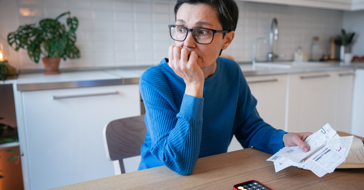 stressed woman surrounded by bills