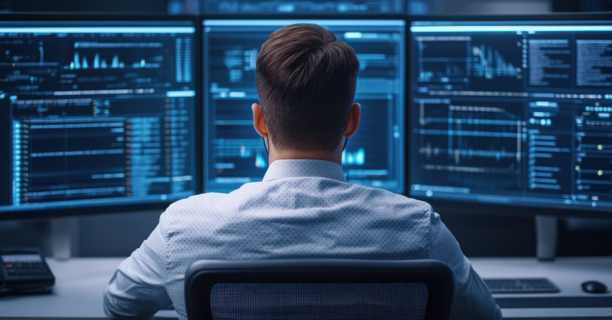 Professional analyst working with multiple computer monitors