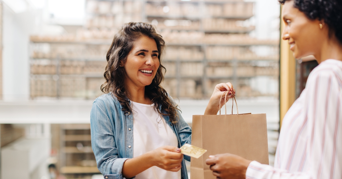 Happy female customer paying with a credit card