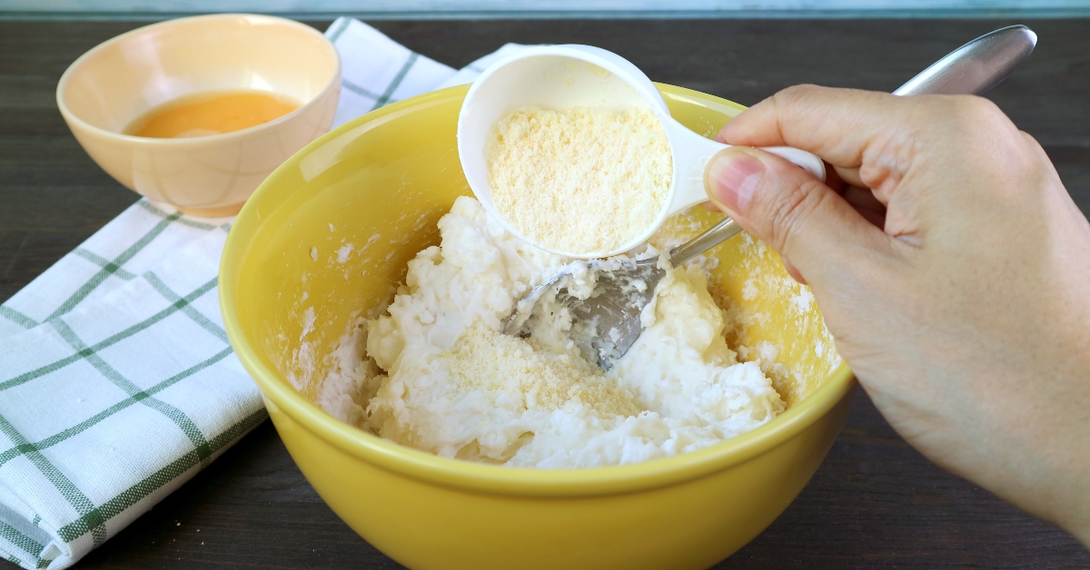 adding parmesan cheese in mixing bowl
