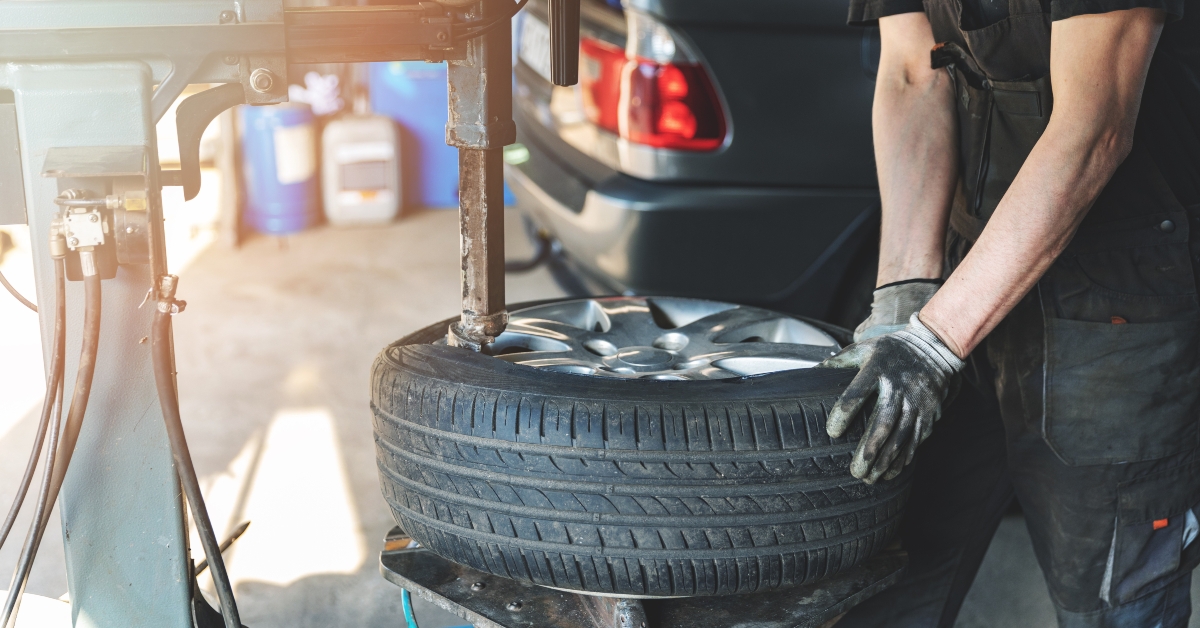 car mechanic changing tire on the rim