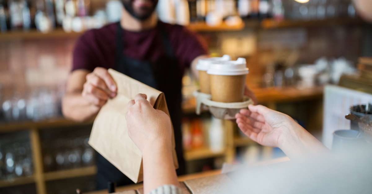 man serving customer at coffee shop