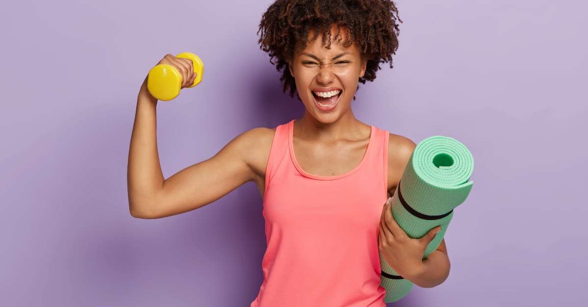 woman raises hand with dumbbell
