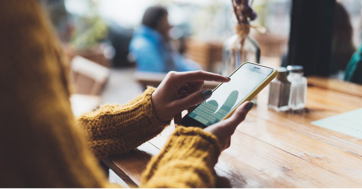 woman at a restaurant using a smartphone