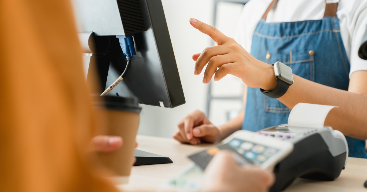 cashier using pos terminal to payment