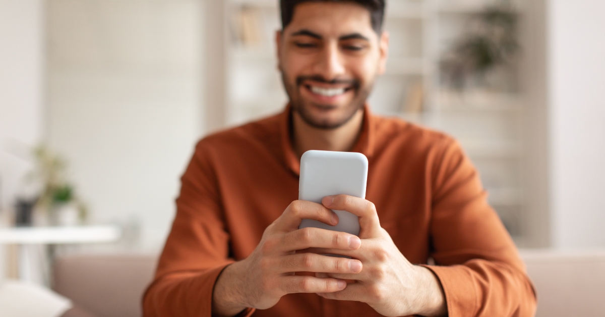 smiling man using smartphone