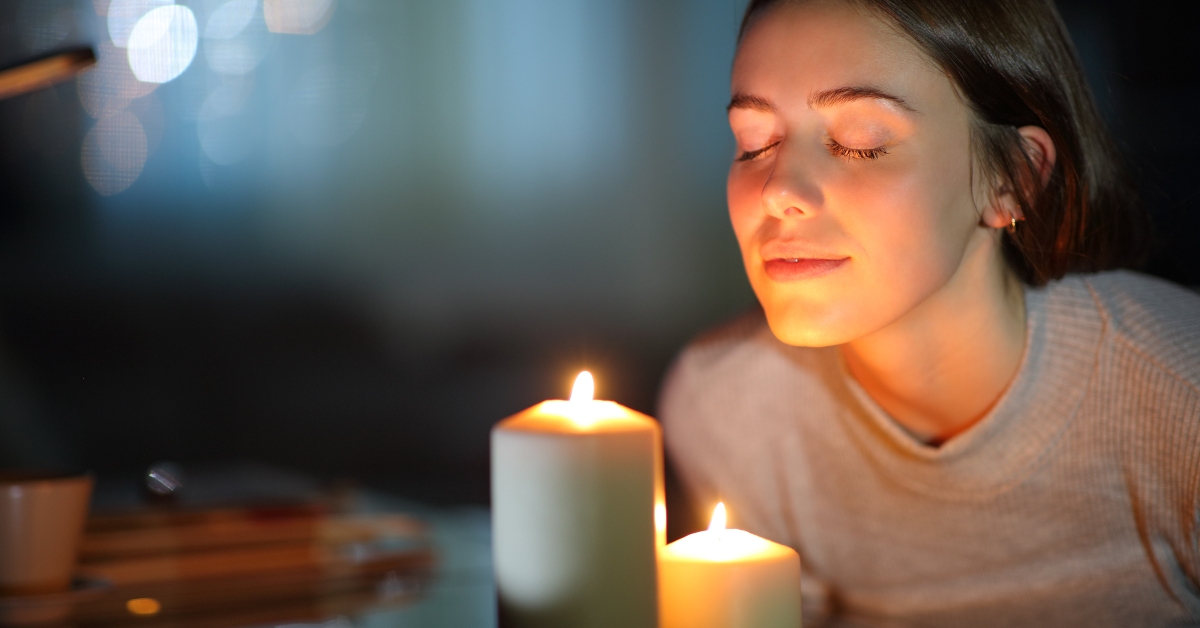woman smelling a lighted candle