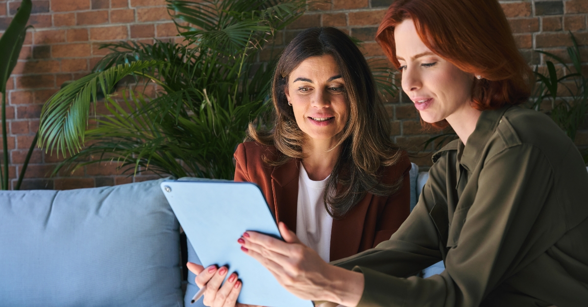 employees looking at digital tablet discussing project at work