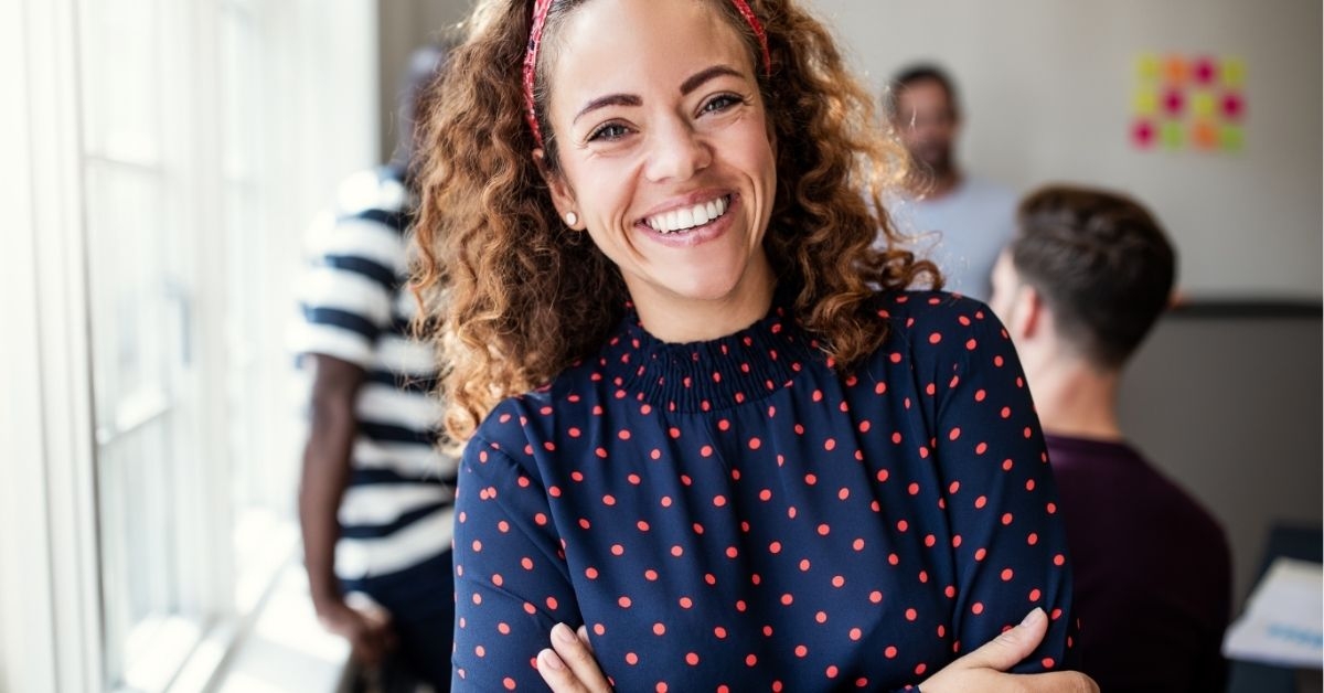 Smiling female designer standing in an modern office 