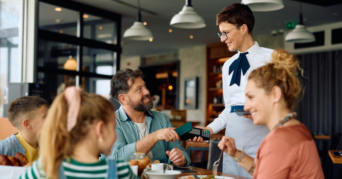 man paying for family breakfast