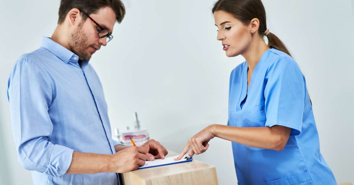 patient signing documents in dental clinic