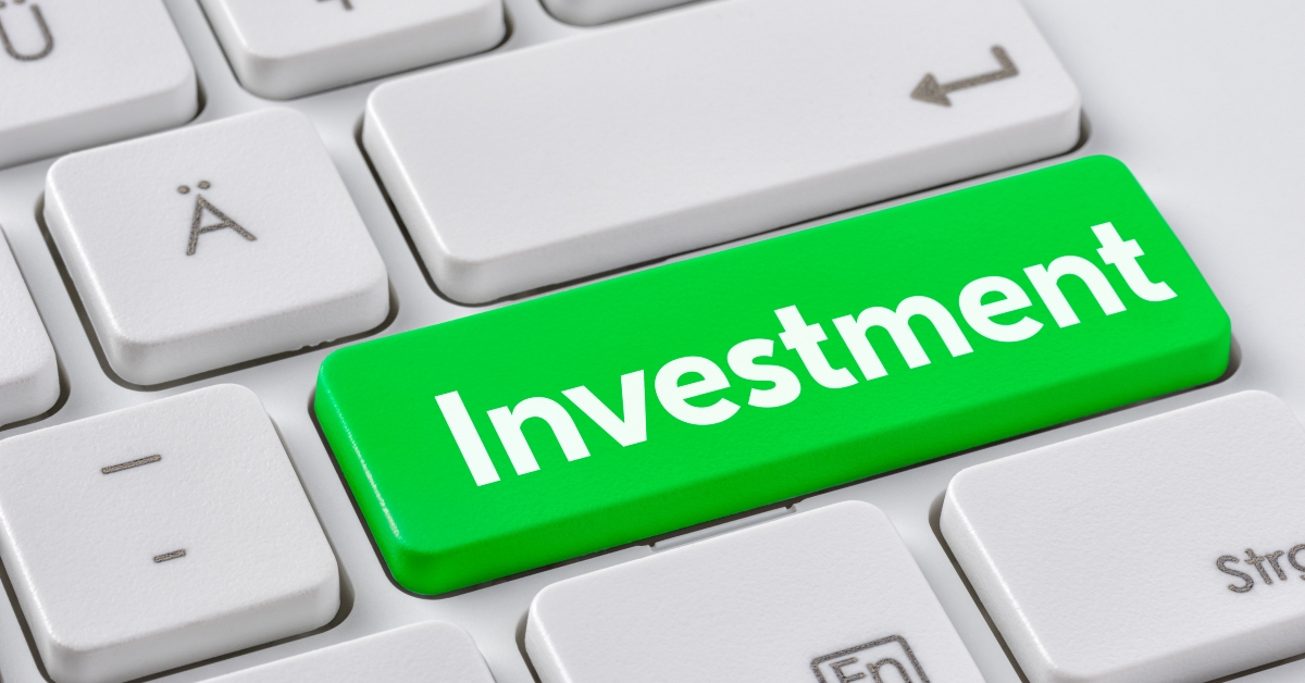 A keyboard with a green button - Investment