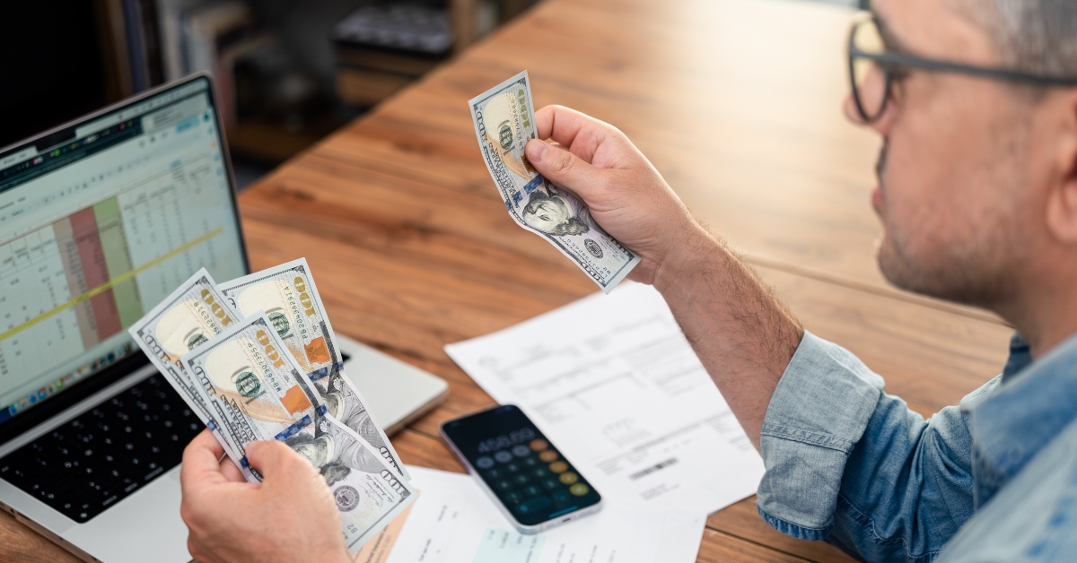 tenant counts dollar bills sitting at table