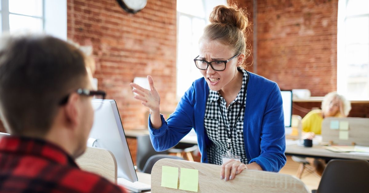 woman annoyed at coworker for distracting her