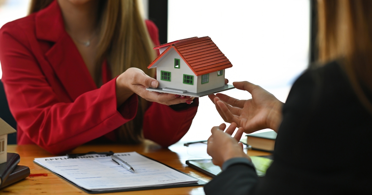young broker woman showing a house model