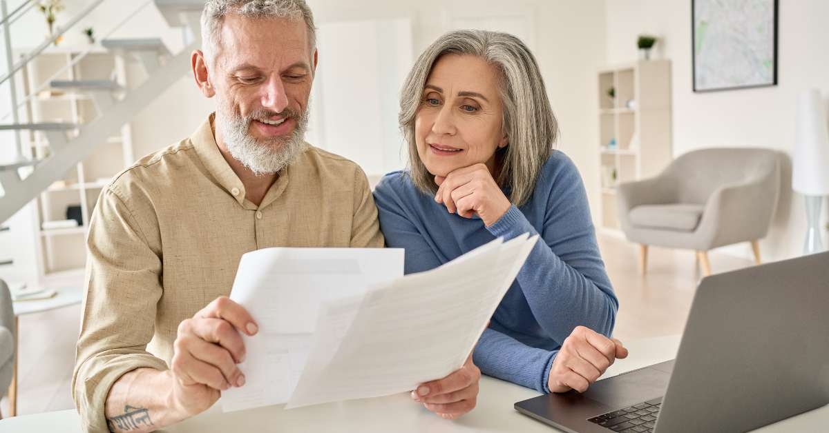 senior old couple holding documents