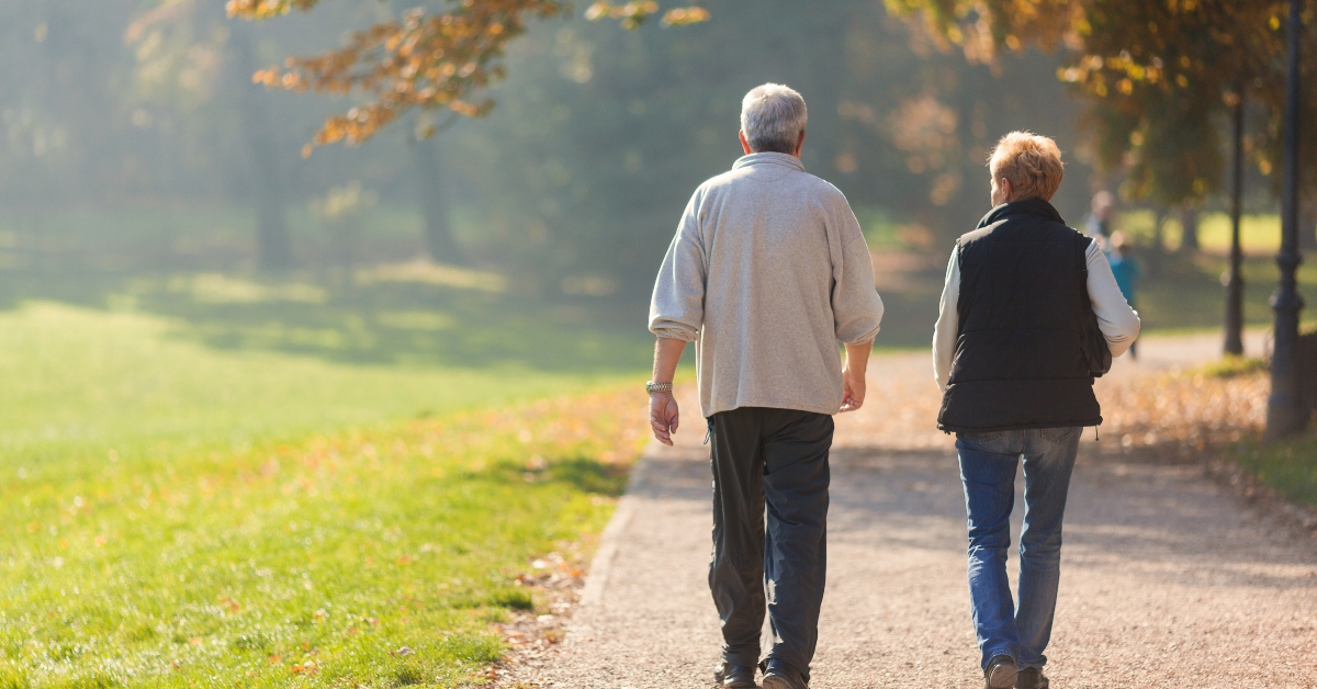 senior couple walking in park together