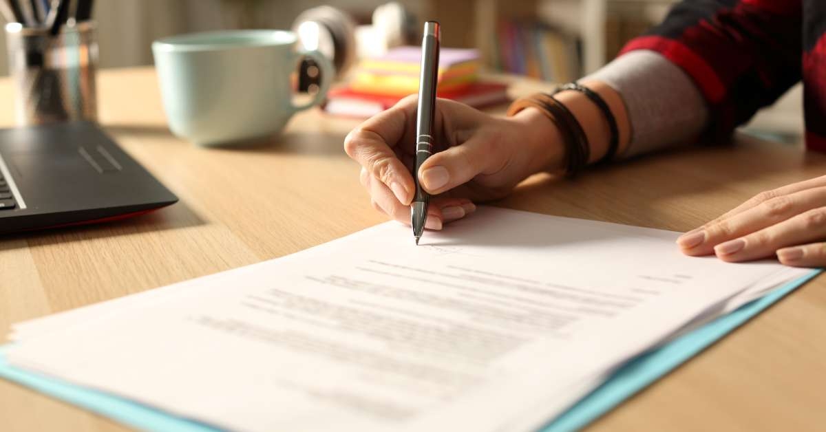 student girl hand signing contract at night