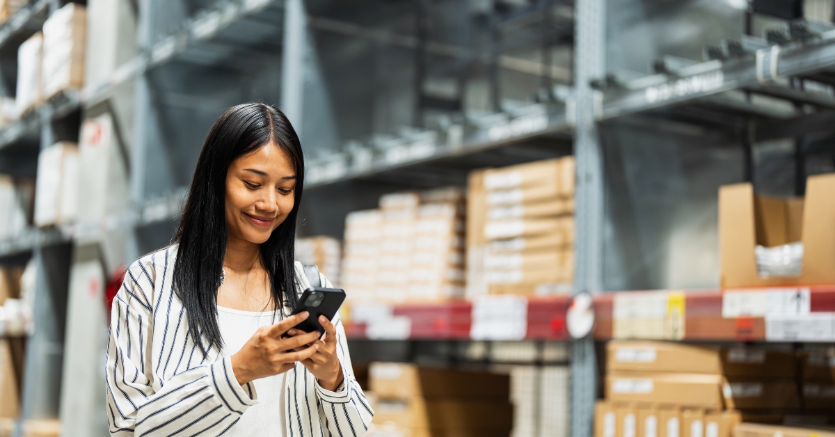 woman using smartphone in a warehouse