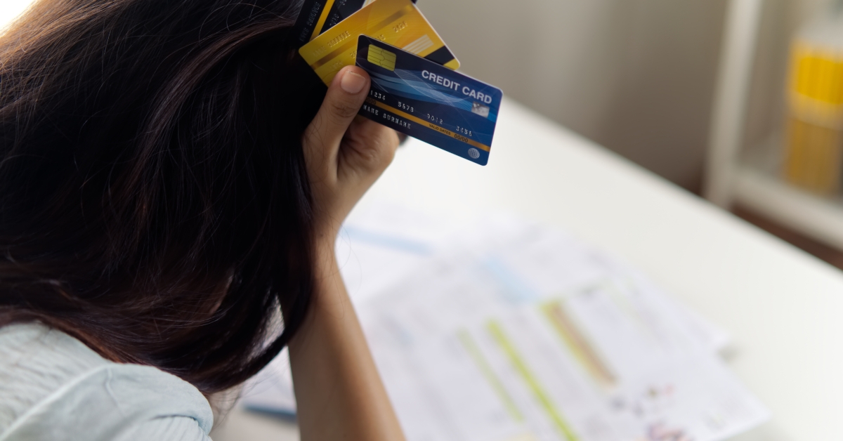 stressed woman holding the head with credit cards