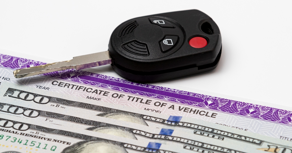 Car key, vehicle title and 100 dollar bills cash