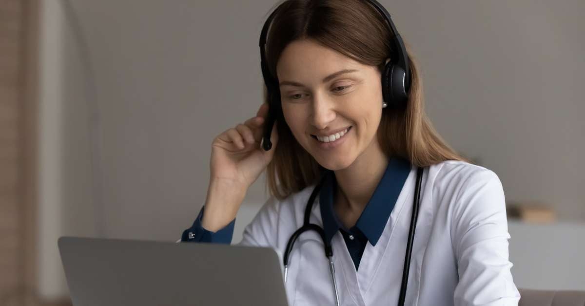 female doctor in headset using laptop