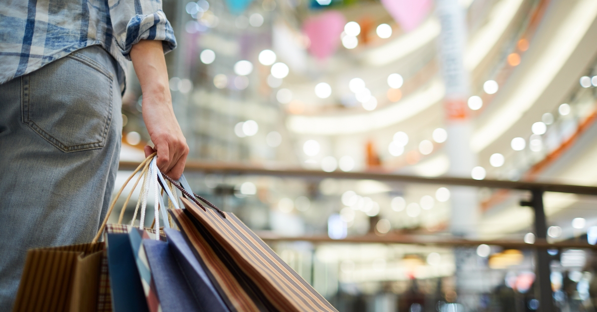 woman at shopping mall holding many paper bags