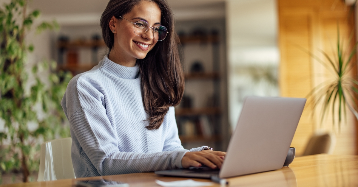 smiling woman working using laptop