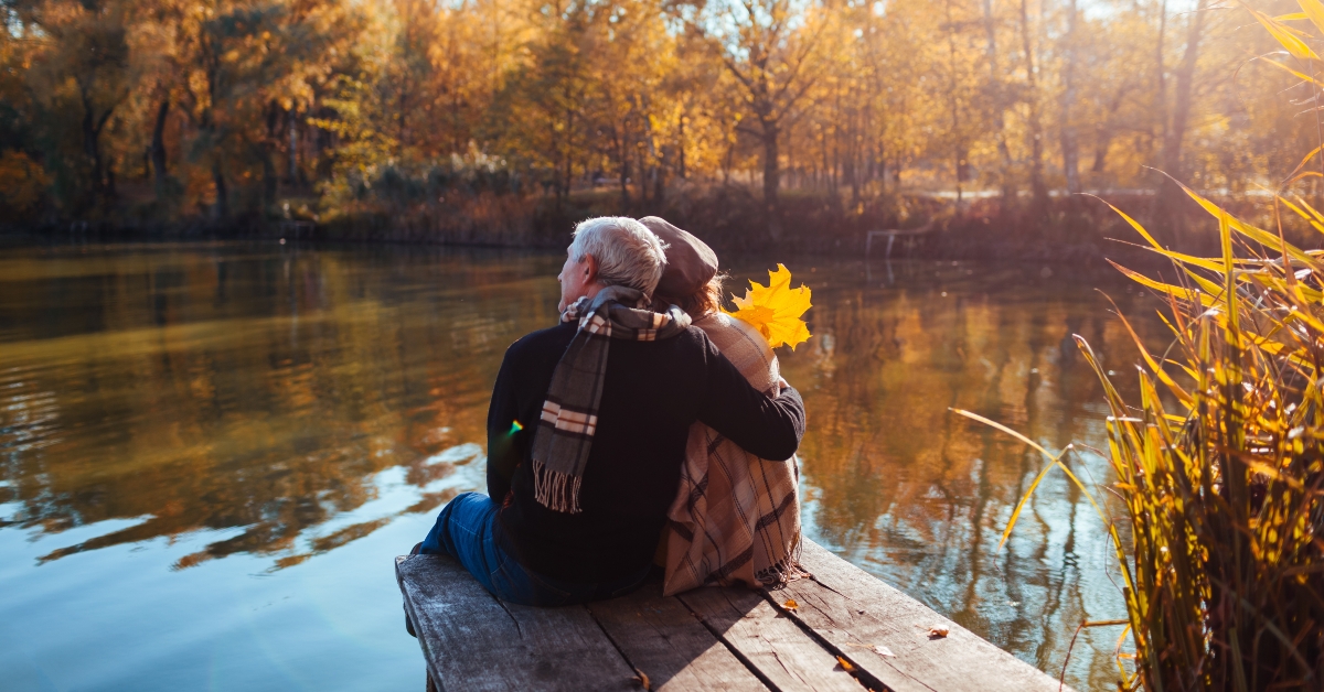 Senior family couple relaxing by autumn lake