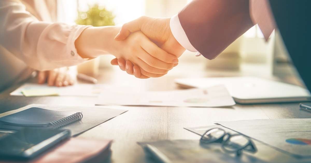 shaking hands above desk