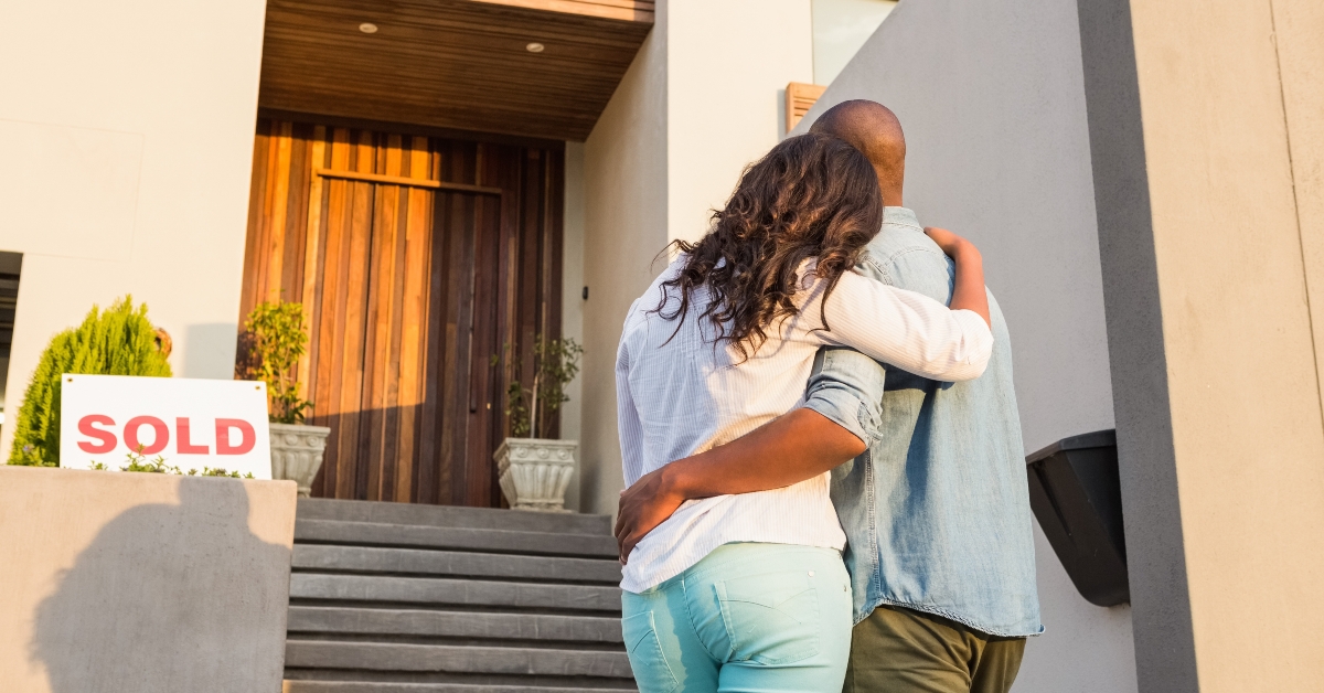 couple in front of their new house