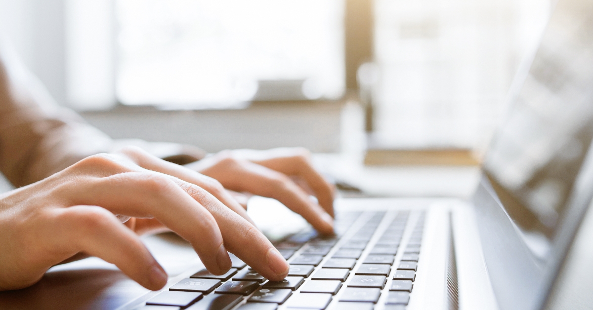 hands typing on laptop