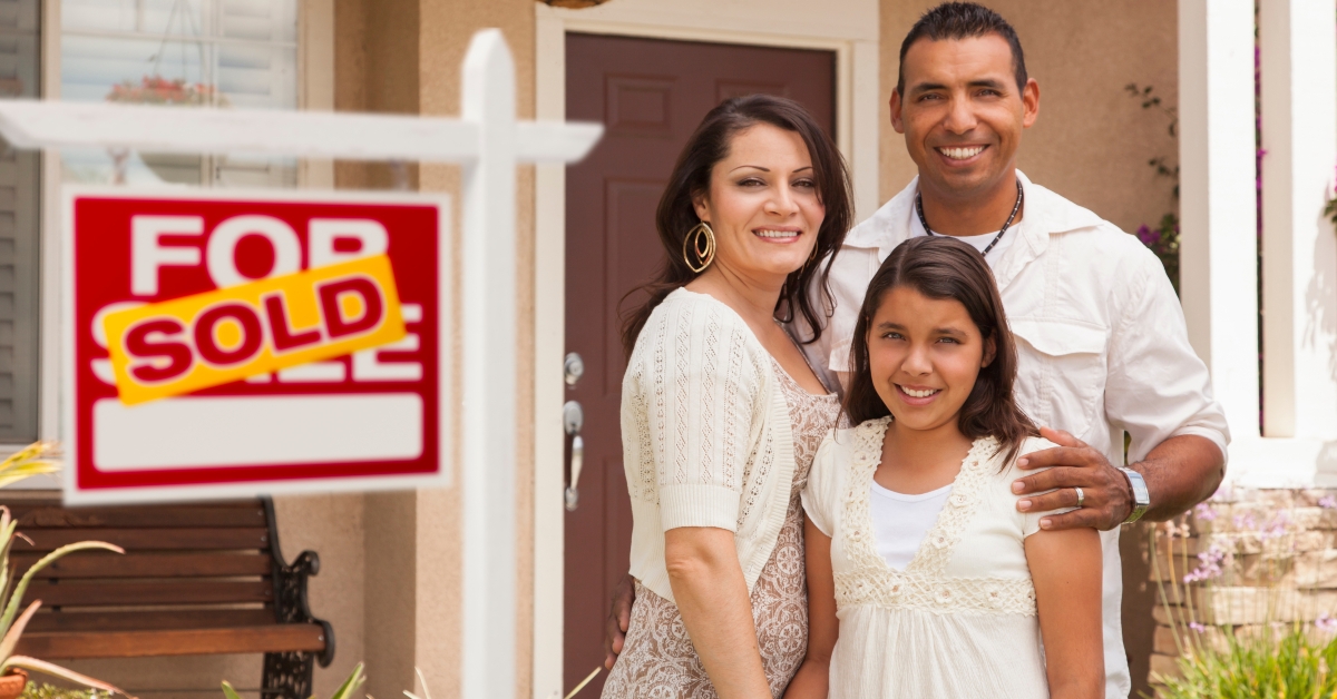 hispanic family in front of their new home
