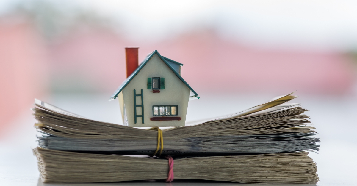 miniature house on stack money