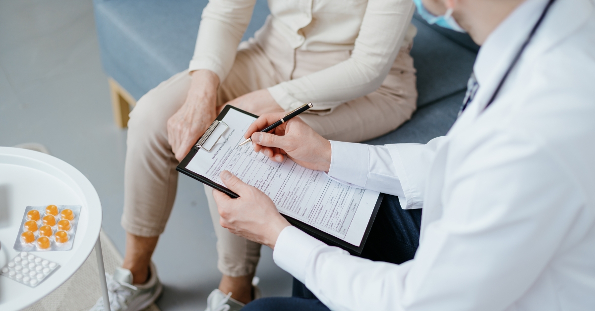 doctor writing out a prescription during a home visit