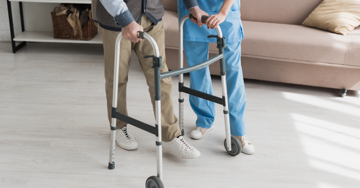senior man walking with nurse