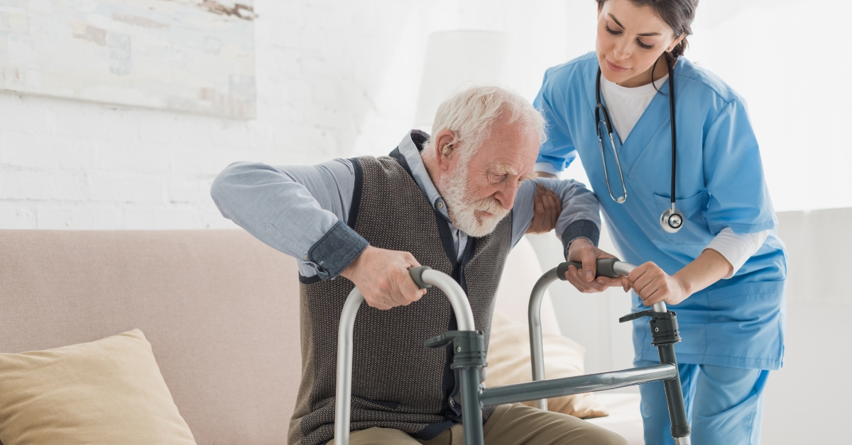 female doctor helping senior man getting up