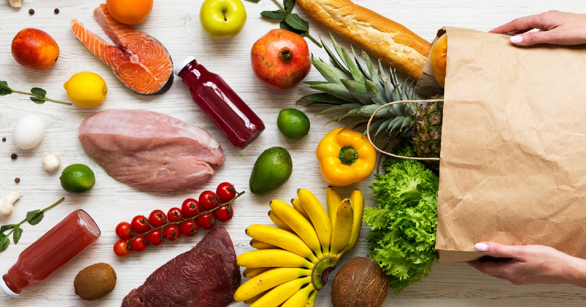 womens hands hold full paper bag of groceries