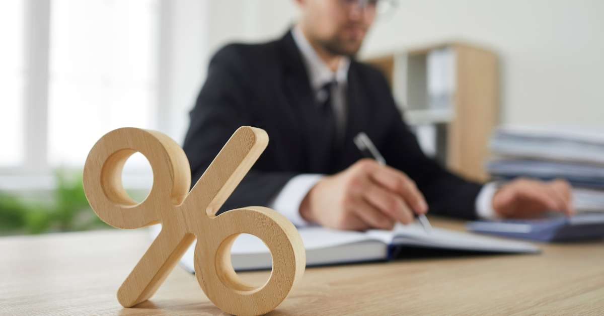 percent sign standing on background of serious busy man