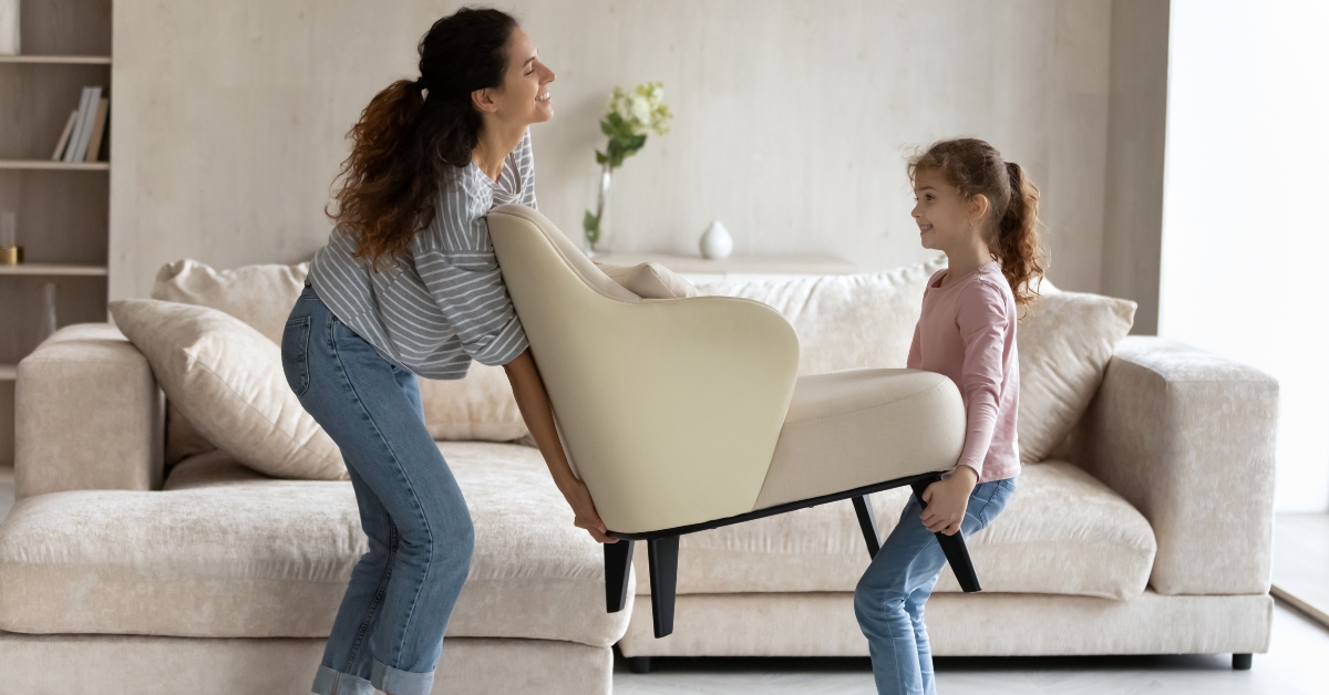 mother and daughter carry a chair