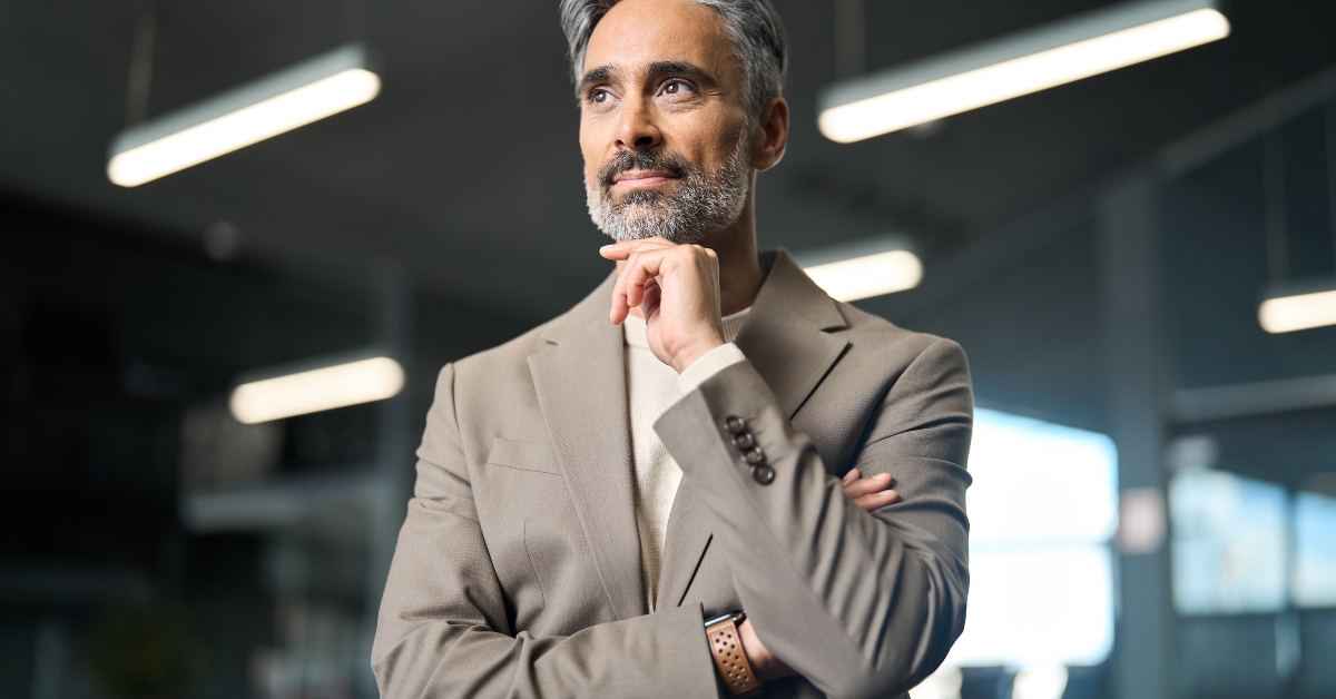businessman standing in office thinking