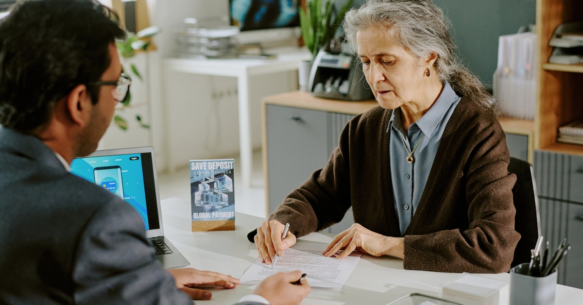 senior woman signing document during meeting