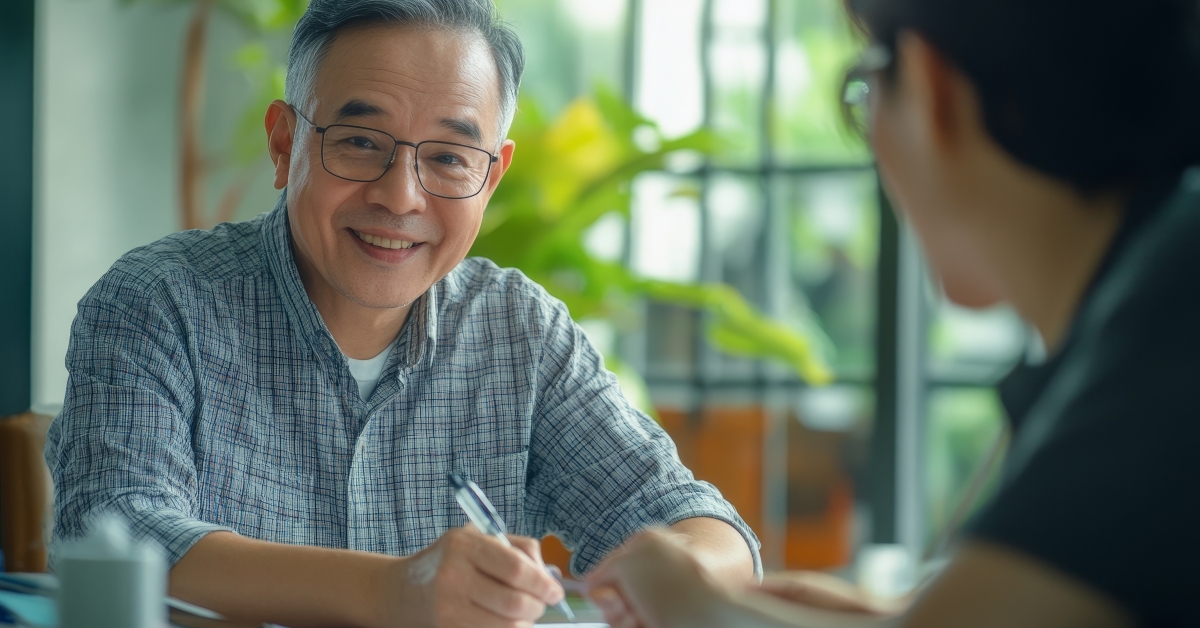 smiling senior man signing document