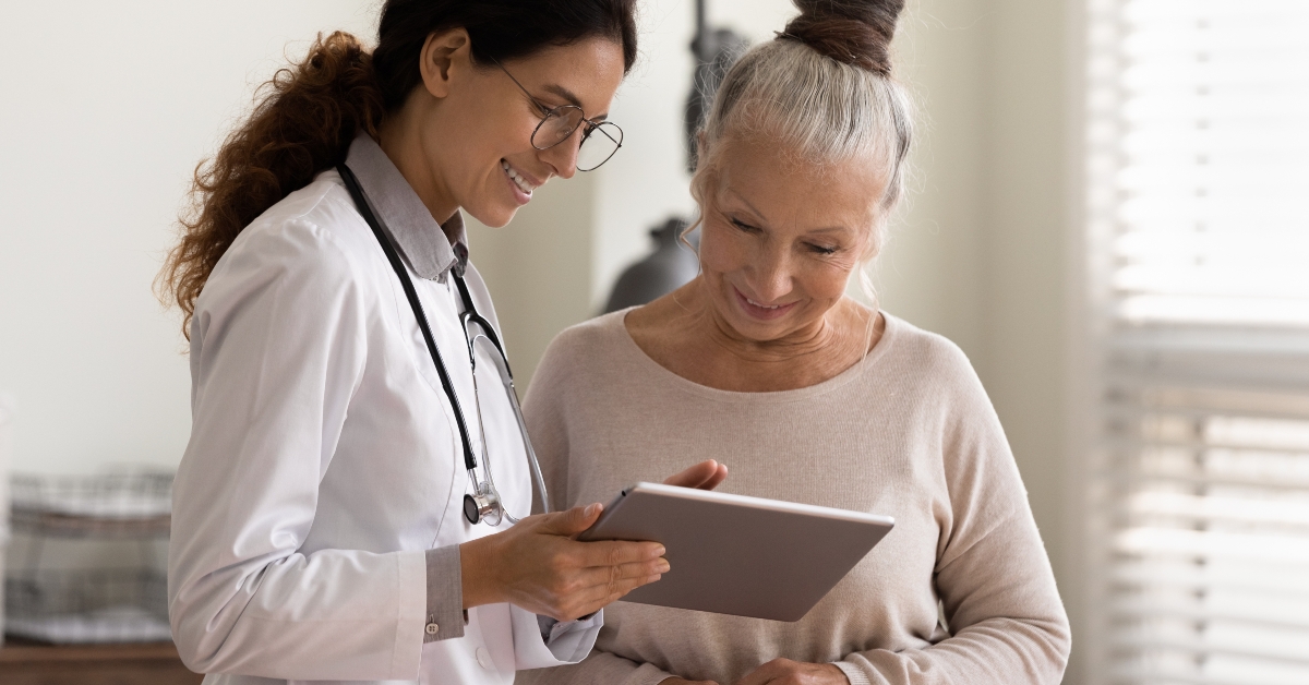 doctor and senior patient look at tablet screen