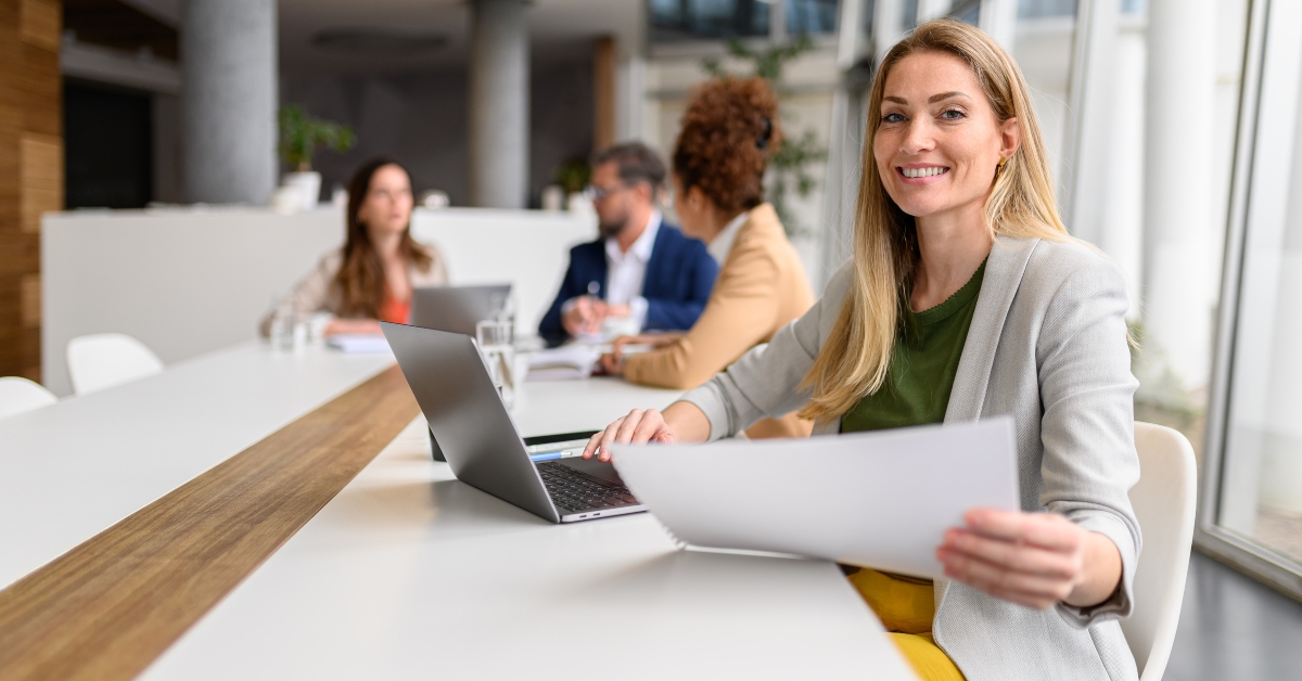 Smiling financial advisor with report and laptop
