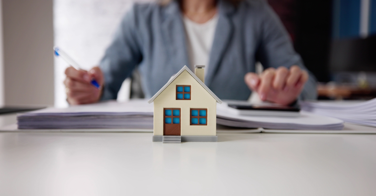 Person Hand Doing Property Tax Calculation Using Calculator 