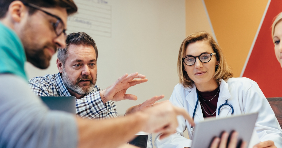 Medical staff during morning briefing in boardroom