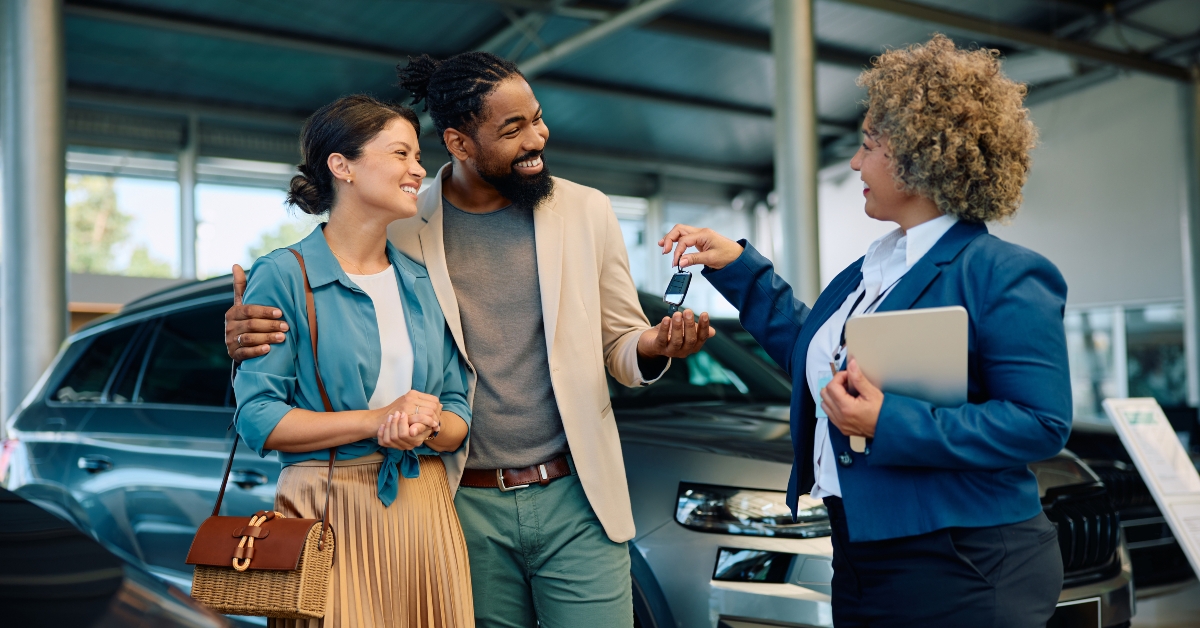 happy couple receiving car keys