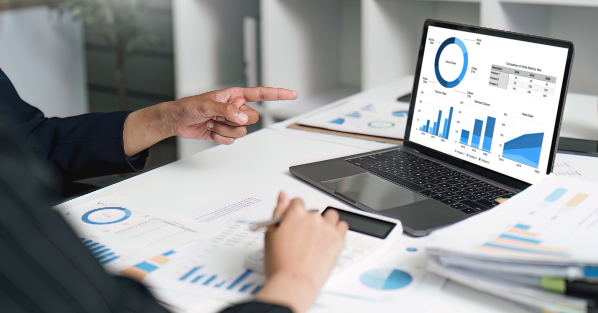 Business professional analyzing financial charts on laptop