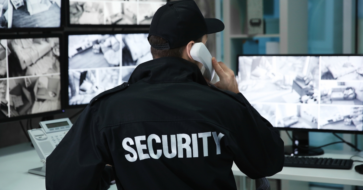 Male security guard talking by telephone in surveillance room